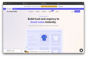 Головна сторінка сайту Wisernotify містить заголовок про побудову довіри та покращення продажів, навігаційне меню вгорі, зображення товару в синій сорочці та графіку онлайн-магазину.
